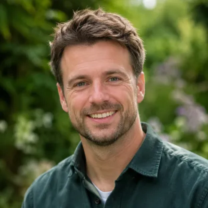 Man van middelbare leeftijd in tuinkleding, glimlachend in een groene tuin